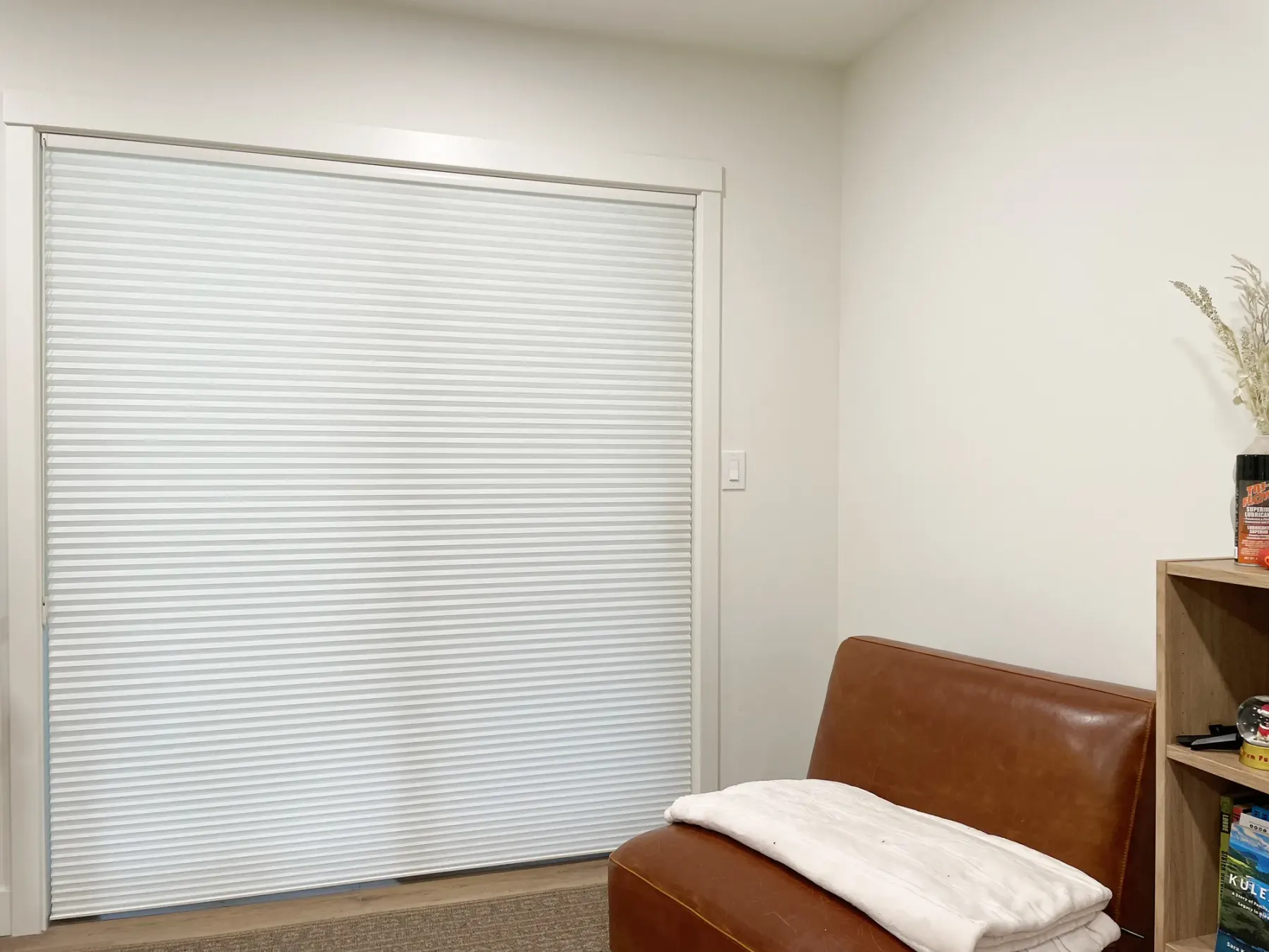 Horizontal honeycomb shades raised above a sliding glass door in a Woodinville family room