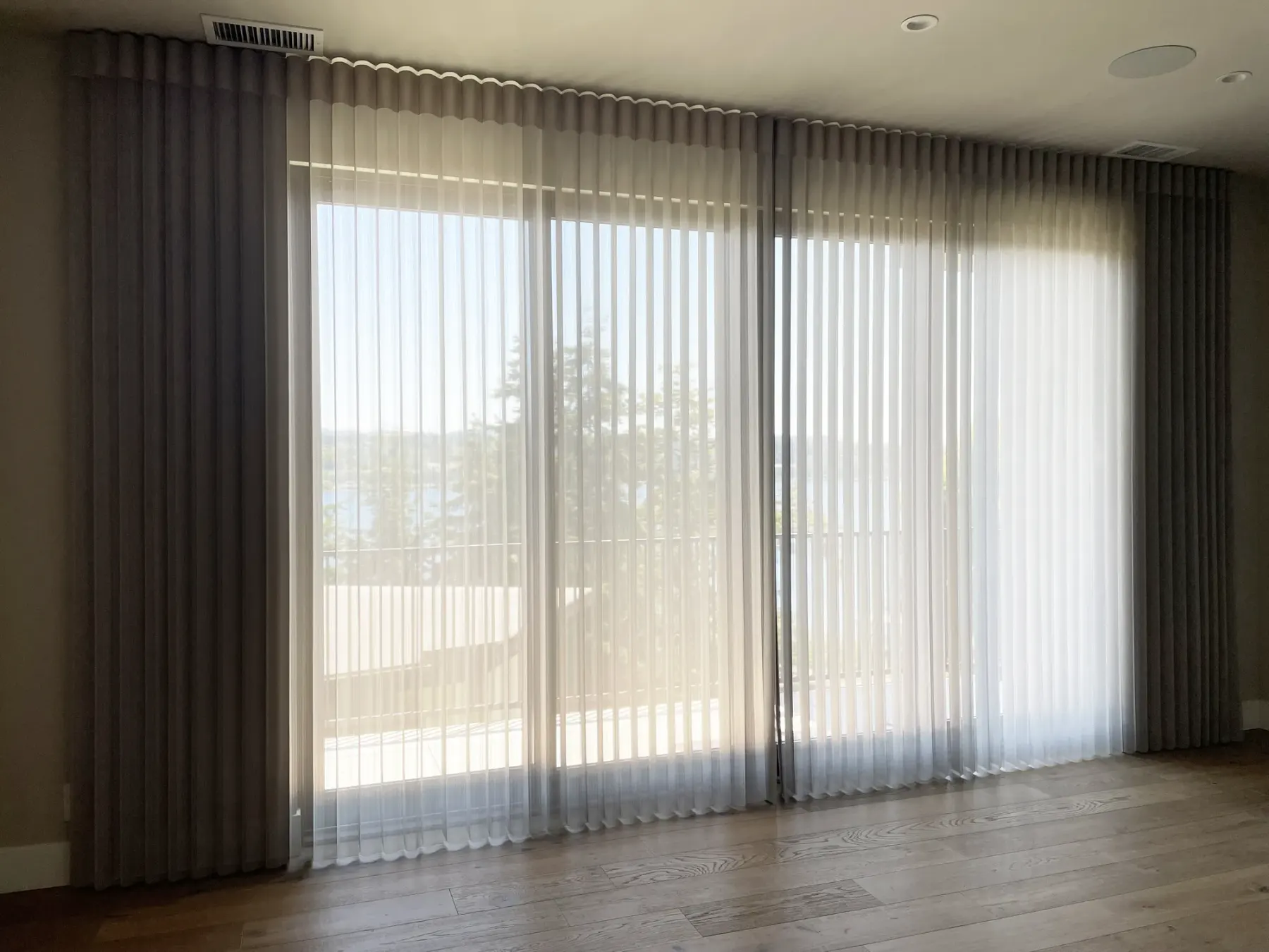 Motorized Luminette vertical sheer shades on a sliding glass door in a Mercer Island master bedroom