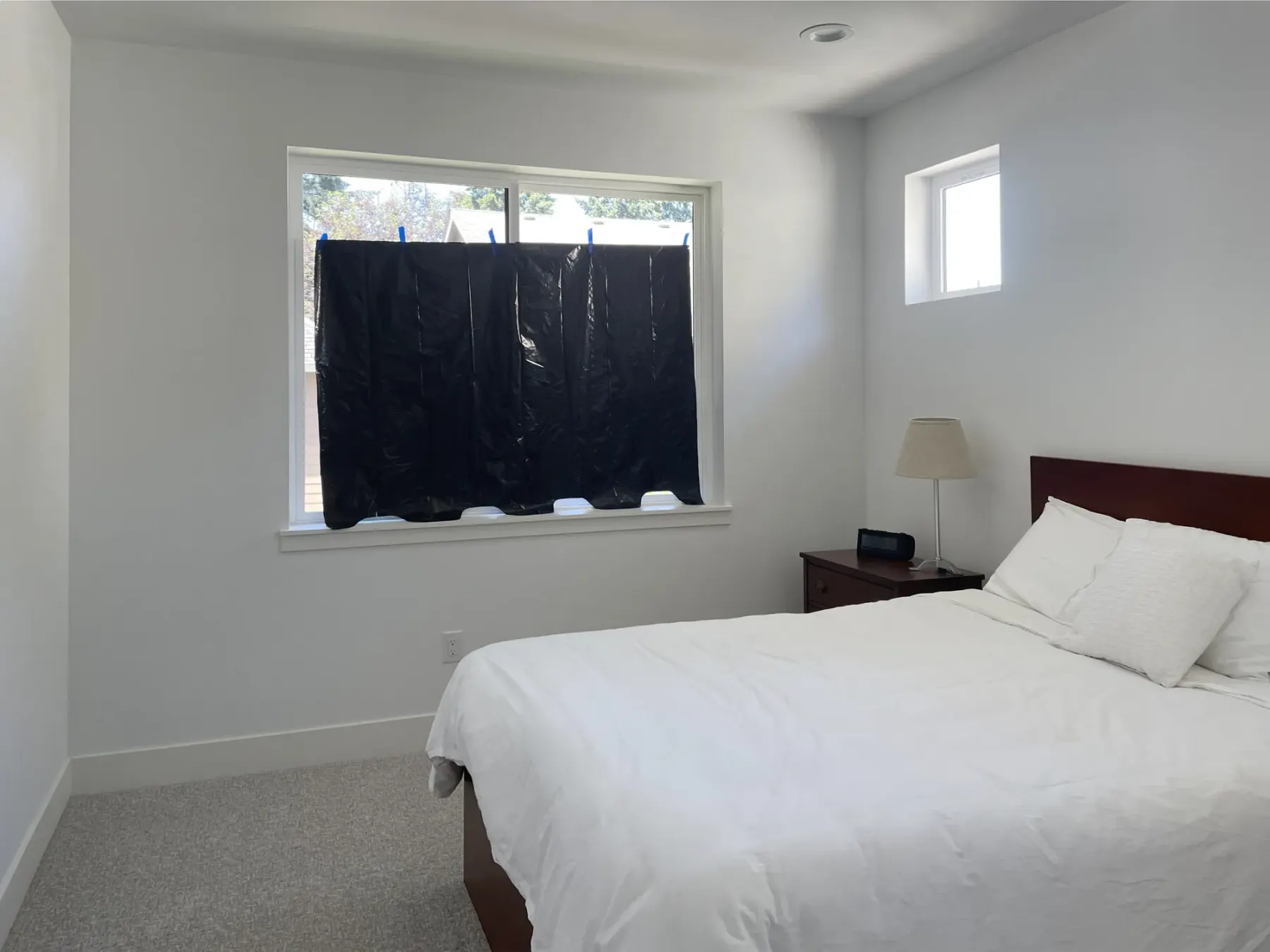 Bedroom window temporarily covered with a garbage bag in a Renton home
